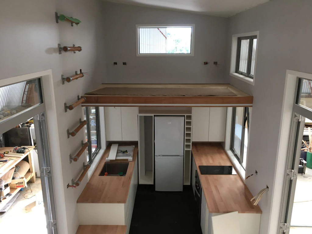 The kitchen and loft space during the build. Photo Credit: Build Tiny