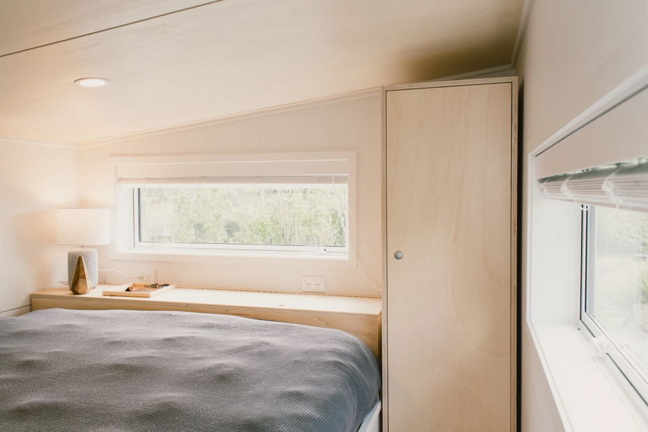 An image of the loft in the archer tiny house, showing a bed and a tiny house loft closet.