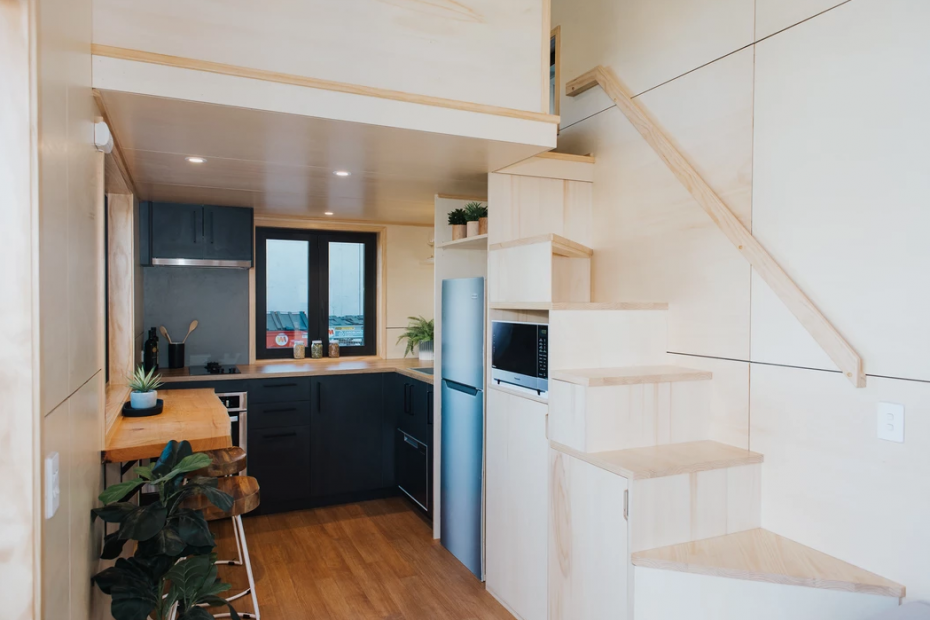 Image of the downstairs kitchen, staircase and loft railing in the Scotty tiny house.