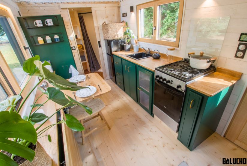The Perseverance tiny house has vertical drawers as a tiny house kitchen storage idea.